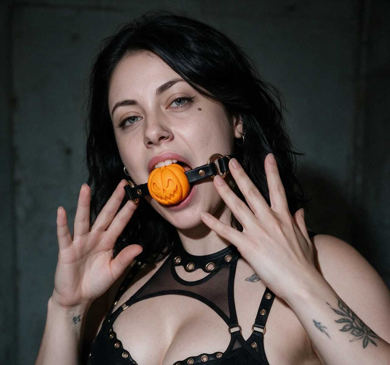 Mara wearing the Pumpkin Gag with her hands framing her face